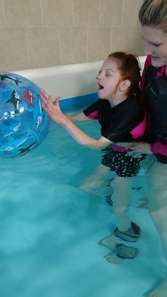child playing with ball in pool